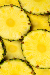 Pineapple juicy yellow slices background. Top view.