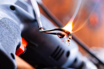Power tool repair. Details of electrical appliance and repair tools on a wooden table in a repair...