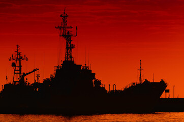 WARSHIPS - A fiery sunrise over the naval base  