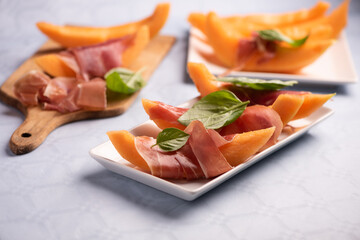 Fresh melon and parma ham on white plate