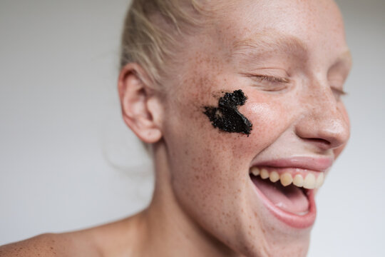 Young model with black scrub on face