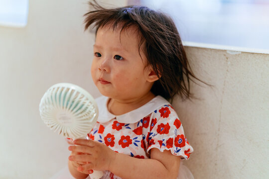 Child blowing a portable fan