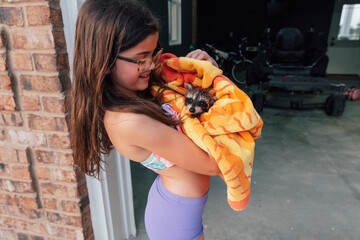 Raccoon wrapped in a beach towel. 