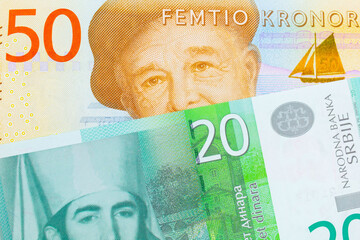 A macro image of a gray and orange fifty kronor note from Sweden paired up with a green and white twenty dinar banknote from Serbia.  Shot close up in macro.