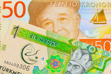 A macro image of a gray and orange fifty kronor note from Sweden paired up with a green and yellow one manat note from Turkmenistan.  Shot close up in macro.