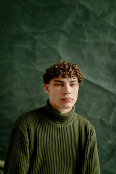studio portrait of a young curly brown-haired man