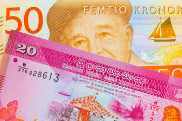 A macro image of a gray and orange fifty kronor note from Sweden paired up with a pink and white twenty rupee bank note from Sri Lanka.  Shot close up in macro.