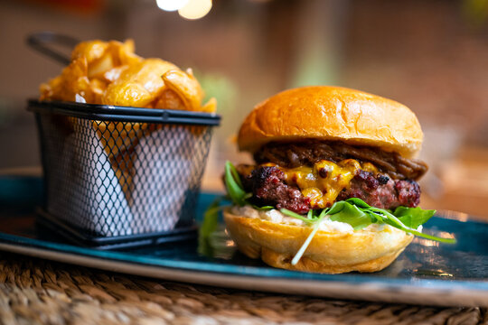 Delicious Burger With Cheese And French Fries. 