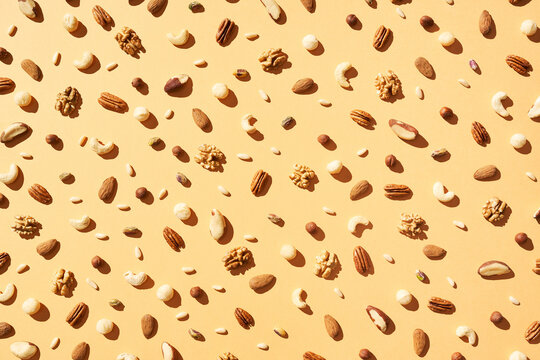 Assorted nuts arranged on beige background