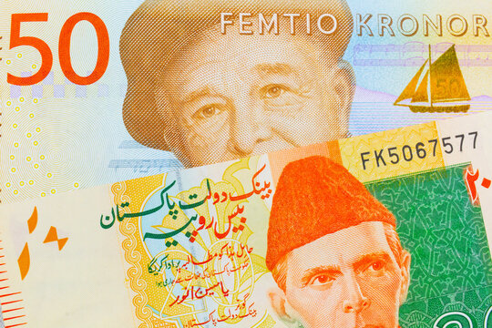 A macro image of a gray and orange fifty kronor note from Sweden paired up with a orange and green 20 rupee note from Pakistan.  Shot close up in macro.