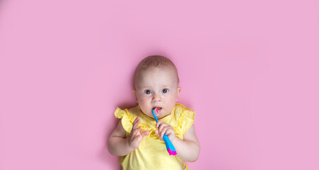 Child kid girl brushing teeth on pink background. Health care, dental hygiene, people and beauty concept. Mockup, free space.