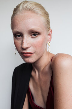 Model wearing red top and earrings