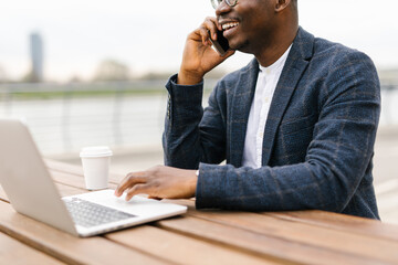 Businessman using his laptop outdoors in a cafe 