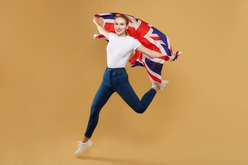 attractive blonde made a jump with a British flag. photo shoot in the studio with a yellow...