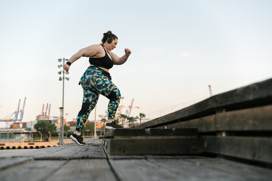 Curvy active woman running down the stairs