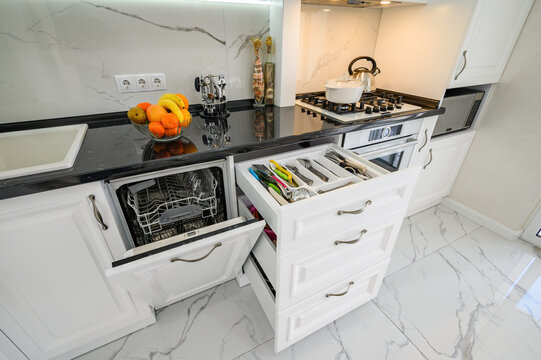 Luxurious White Modern Kitchen Interior, Drawers Pulled Out, Dishwasher's Door Open, High Angle