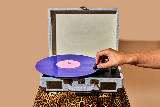 man plays a disc in a portable turntable