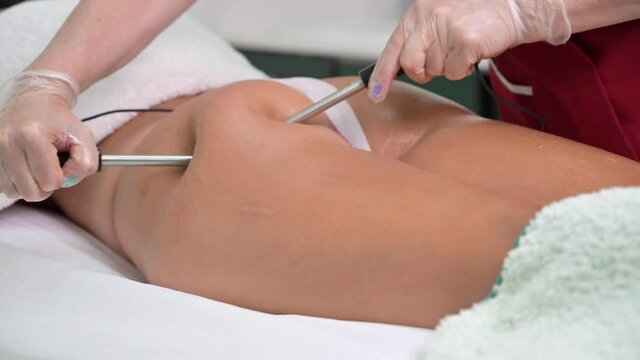 Woman having cosmetic galvanic beauty treatment in spa. Therapist applying low frequency current. High quality 4k footage