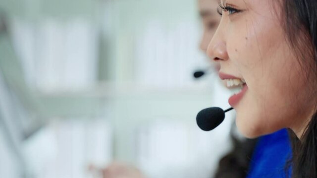 The beautiful call center staff are typing keyboards and talking in a friendly way, providing smiling services, caring for the service.
