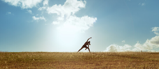 young female doing stretching exercises outdoors in a beautiful nature setting. 