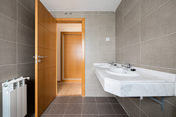 Simple bathroom of brand new modern apartment with white marble sink countertop.