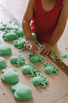 Asian boy playing kinetic sand