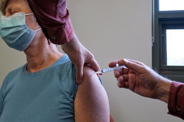 Middle aged women receiving the Covid-19 vaccination and feeling discomfort