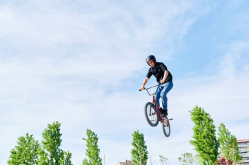 Young man doing a BMX stunt in a park