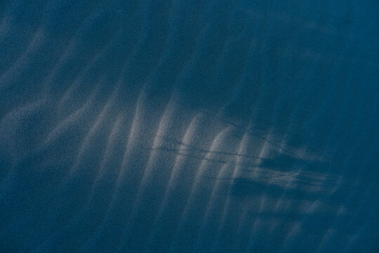 Ripple texture in the sand and long shadows