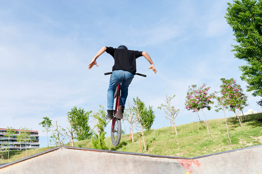 Young man doing a BMX stunt in a park