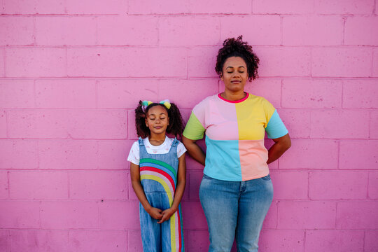 Mom and girl standing with eyes closed