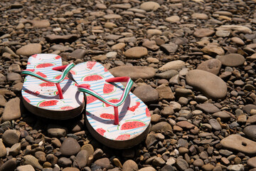 slippers flip flops on a stone beach