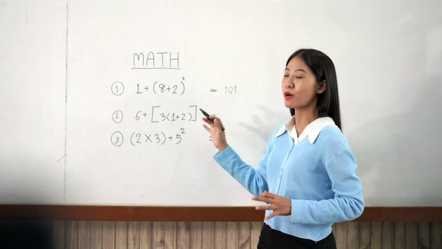 Educational concept a young smart female teacher explaining decision of hard math in a classroom 