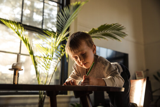 Little boy drawing during sunset