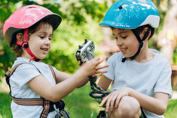 Cute, beautiful children, a boy and a little girl in protective helmets. Children have fun...