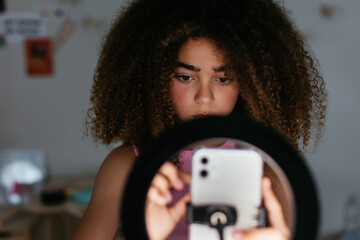 Hispanic girl using preparing to record video for blog