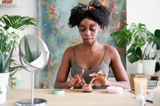 Black Woman Applying Facial Mask During Beauty Procedure