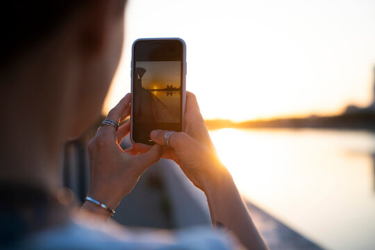 Woman Taking Pictures With The Phone At Sunset
