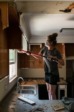 Woman working on remodeling outdated kitchen.