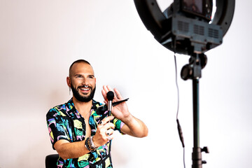 Young man showing his brushes recording a tutorial