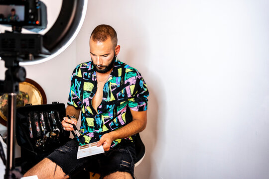 Young man recording a video tutorial putting on makeup 