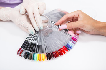 Cropped close up of a client choosing nail polish color from the palette