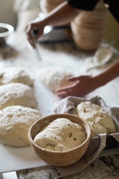 Bowl with dough near baker preparing bread
