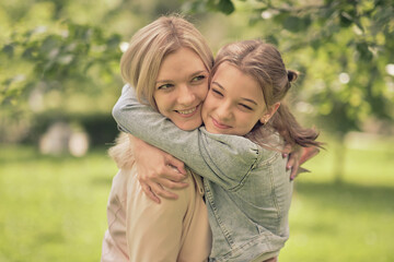 happy mother with her daughter hugging a teenager in the summer. Caring happy mother enjoy day with teenage girl child, laugh have fun. Mother giving her daughter advice.