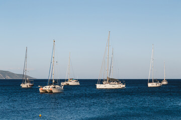 Obraz na płótnie Canvas White yachts anchored in a blue bay of Agia Efimia port, Cephalonia island, Greece