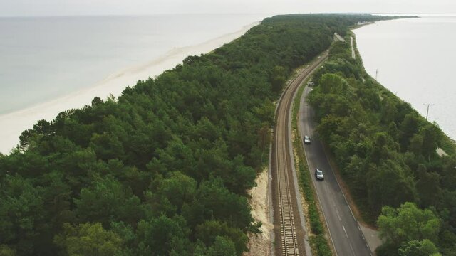 Road along the coastline. Forest covered peninsula in Poland seen from above