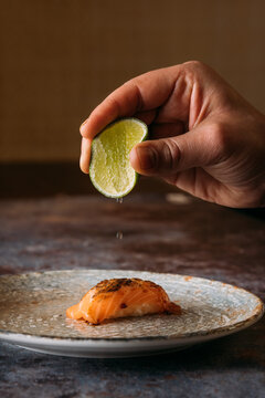 Chef pouring lime drops over delicious salmon nigiri