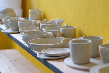 Unfinished clay pots on shelves as part of a ceramic pottery workshop. Creative studio potter....
