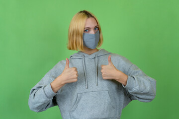 Optimistic woman wearing protective mask as protection against coronavirus pandemic covid-19