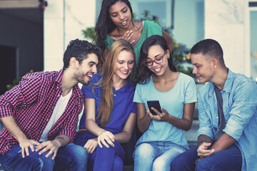 Influencer girl with mobile phone and group of young adult friends